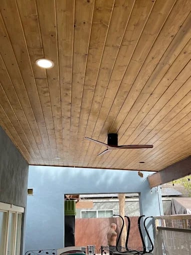 Covered patio with wooden plank ceiling, recessed lighting, and ceiling fan